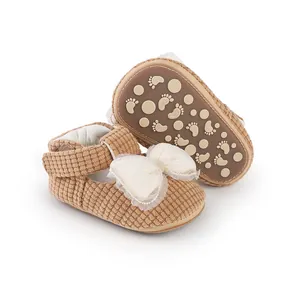 Detail of brown corduroy baby walker shoes with cream lace bow and anti-slip sole