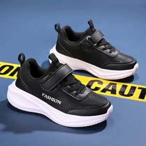 Gros plan de baskets noires pour garçons avec maille respirante et semelle blanche