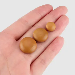 Set of three natural poplar wood buttons in different sizes displayed on a palm.