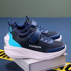 Gros plan de baskets de sport bleu foncé pour garçons avec bande velcro et semelle