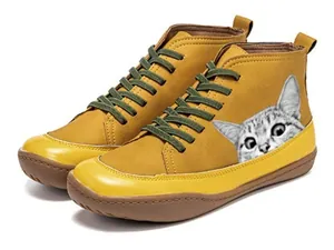 Detailed view of yellow high-top boots with cat print and green laces