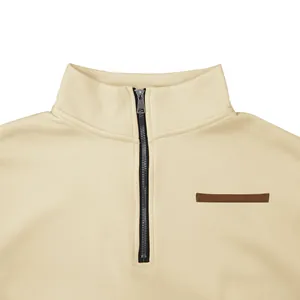 Close-up detail of cream half-zip pullover sweatshirt with stand collar and metallic zipper