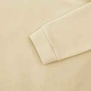 Detailed macro view of the ribbed cuff on a beige oversized men's casual fleece sweatshirt