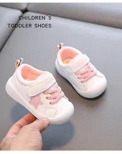 Detalle de zapatos de cuero blanco para niños pequeños con estrella rosa y velcro