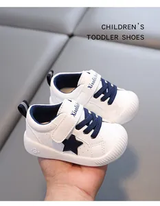 Detalle de zapatos blancos para niños con estrella azul oscuro y cierre de velcro para bebés.