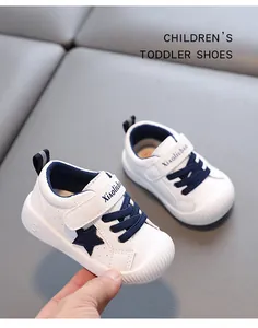 Detalle de zapatos de cuero blancos para niños con estrella azul y suela antideslizante