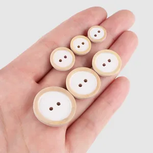 Natural poplar wood buttons in various sizes shown on a hand to demonstrate scale