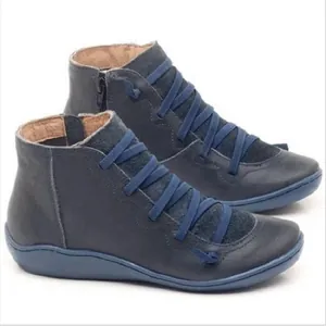 Detalle de botines azules para mujer con correas elásticas cruzadas y cremallera lateral