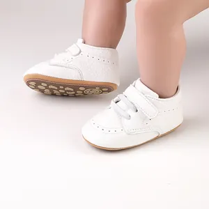 Detailed view of white faux leather baby walking shoes featuring a secure hook-and-loop strap