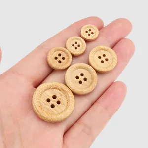 Assortment of natural bamboo buttons in multiple sizes shown held in a human palm for scale