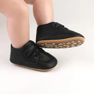 Close-up of black faux leather baby walker shoes with non-slip footprint sole