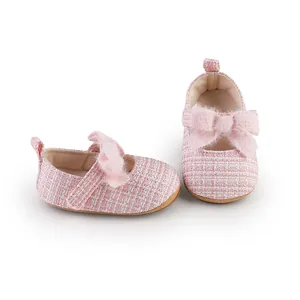 Detail der rosa Tweed-Babyschuhe für Mädchen mit Plüschschleife und weicher Sohle.