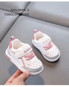 Close-up of pink and white toddler sneakers held by hand to show soft breathable design.