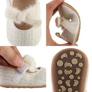 Detailansichten weißer Baby-Prinzessinnen-Schuhe mit flauschiger Schleife und Gummisohle