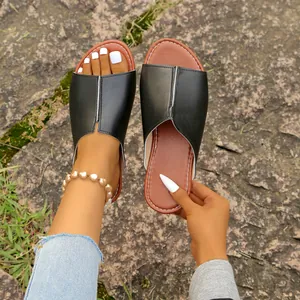 Bequeme schwarze Damen-Pantoletten für den Sommer in einer natürlichen Außenumgebung.