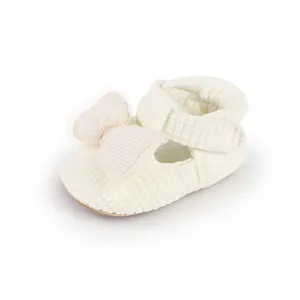 Detailed view of baby girl's cream walker shoe with a decorative mesh bow