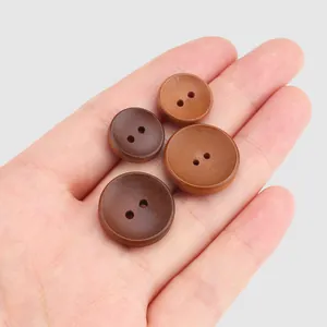 Boutons ronds à deux trous en bois de peuplier naturel de tailles variées sur une main