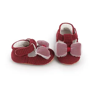 Close-up detail of red corduroy baby walking shoes featuring large decorative mesh bows