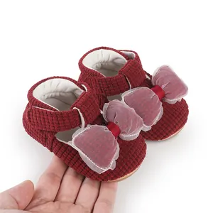 Detail view of burgundy corduroy baby shoes with a large sheer mesh bow