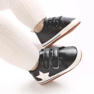Dettaglio scarpe primi passi nere per neonati con stella bianca e chiusura a velcro
