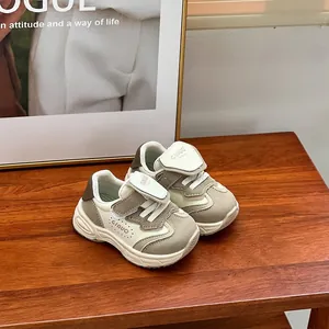 Primer plano de zapatillas casuales beige para niños con suelas blandas sobre mesa