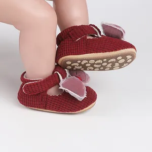 Detail of red waffle fabric baby shoes with mesh bow and non-slip sole.