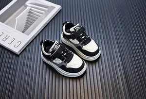 Stylish black and white kids sneakers with 1987 branding on a trendy background.