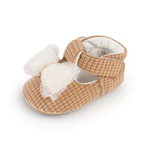 Macro view of brown corduroy baby walking shoe featuring a large white mesh bow