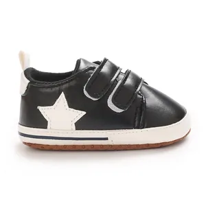 Dettaglio scarpe primi passi nere per neonati con stella bianca e chiusura a strappo