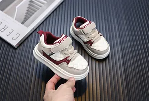 Toddler sneakers with quilted pattern and burgundy accents on a dark background