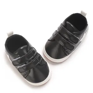 Primo piano di scarpe primi passi nere per neonati con stelle bianche e suole morbide antiscivolo