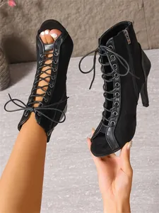 Detalle de botines de baile negros con cordones, punta abierta y tacones de aguja finos