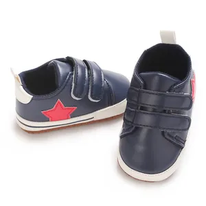 Scarpe da neonato blu navy con stella rossa e chiusura a strappo, dettaglio suola.