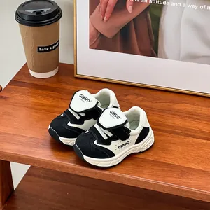 Elegantes zapatillas infantiles en blanco y negro con suelas blandas y diseño casual para niños