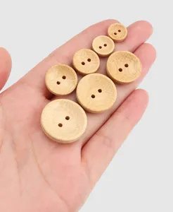 Detailed macro view of natural eco-friendly bamboo buttons held in a human hand