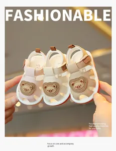 Detailed view of three colors of cute cartoon bear baby sandals held by hands for infants