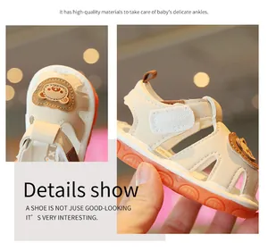 Detailed view of cream baby sandals with cute bear patch and secure velcro strap