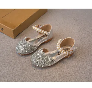 Silver sequin girl's princess sandals with pearl ankle strap on grey background
