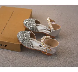 Close-up of silver sequined girls' princess shoes with pearl straps and heels.