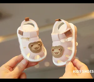 Close-up of pink toddler sandals featuring a cute cartoon bear patch detail