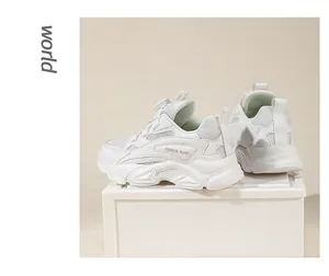 Detail view of children's white sneakers featuring dial lacing system and mesh texture