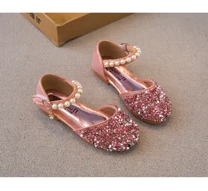 Close-up of pink sequined girls princess shoes with elegant pearl straps and charms.
