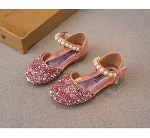 Detailed macro view of pink sequined girls' princess Mary Janes with elegant faux pearl straps