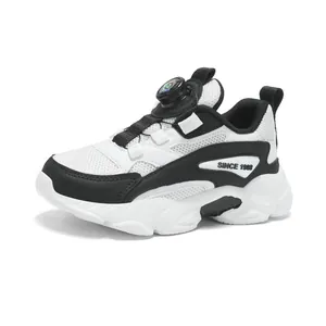 White and black children's athletic running shoes featuring a rotary buckle lacing system