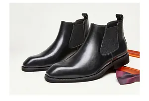 Detailed macro view of black genuine leather Chelsea boots with square toe design