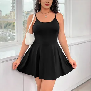Modelo con un cómodo vestido corto negro de tirantes finos de talla grande junto a una ventana