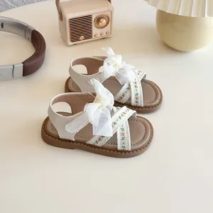 Elegantes sandalias de verano para niña en blanco roto con lazo y bordado floral