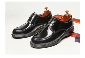 Elegantes zapatos derby de charol negro con acabado brillante para traje de gala.