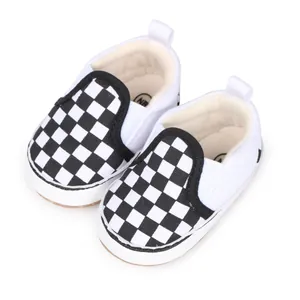 Primer plano de zapatos de lona para bebé a cuadros blancos y negros con suela blanda