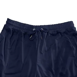 Detail view of men's navy blue joggers featuring an adjustable drawstring and elastic waist.